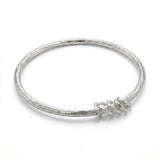 Amali Jules UK sterling silver bangle with a molten texture and five free-moving hammered accent rings.